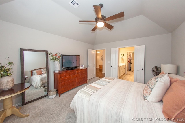 bedroom featuring light carpet, vaulted ceiling, ceiling fan, and ensuite bathroom