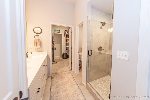 bathroom with vanity, toilet, tile patterned flooring, and a shower with door