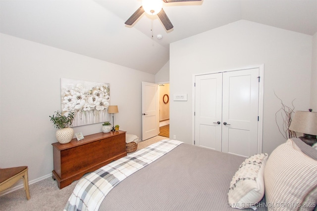 carpeted bedroom with ceiling fan, lofted ceiling, and a closet