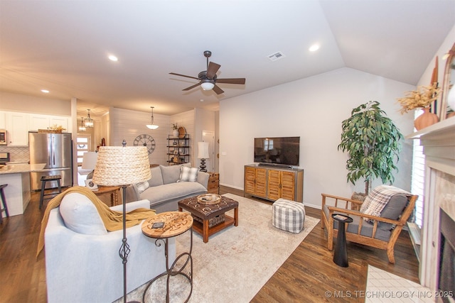 living room featuring ceiling fan, lofted ceiling, and light wood-type flooring