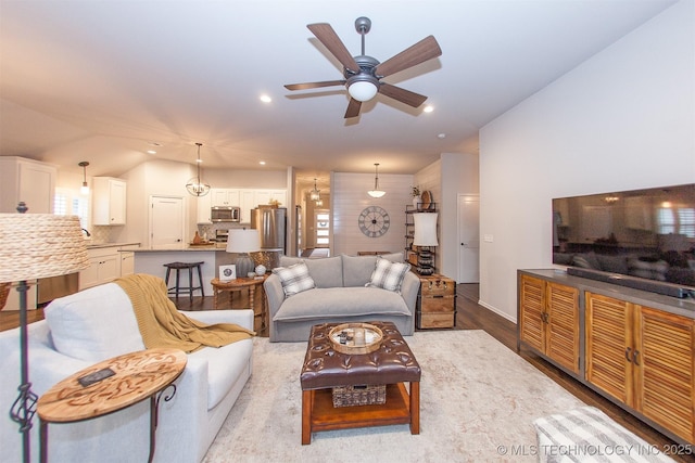 living room with ceiling fan, lofted ceiling, and light hardwood / wood-style floors