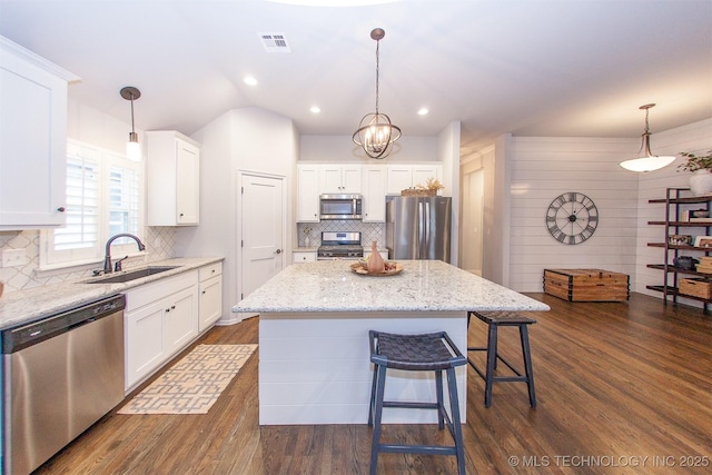 kitchen featuring white cabinetry, stainless steel appliances, sink, and a kitchen island