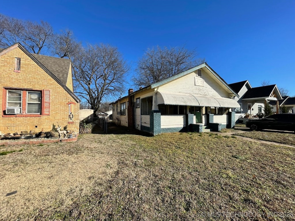 view of side of property featuring cooling unit and a lawn