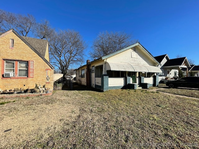 view of side of property featuring cooling unit and a lawn