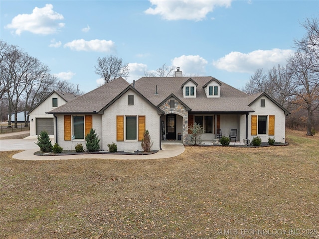 view of front facade featuring a garage, a front yard, and covered porch