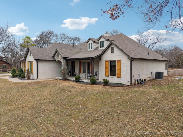 view of front of house with cooling unit, a patio, and a front yard