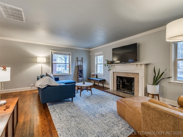 living room with dark wood-type flooring, ornamental molding, and a premium fireplace