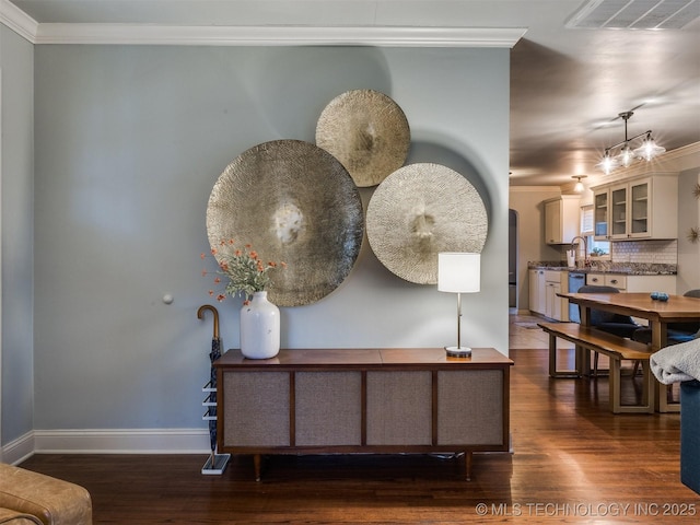 room details featuring sink, hardwood / wood-style flooring, ornamental molding, decorative backsplash, and stainless steel dishwasher