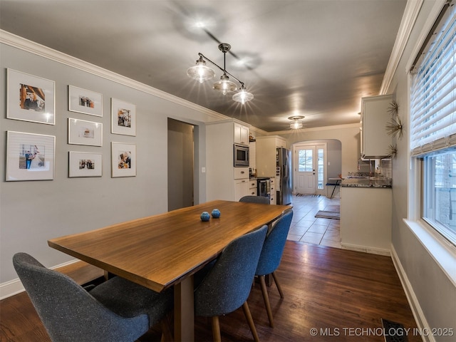 dining space with crown molding and dark hardwood / wood-style floors