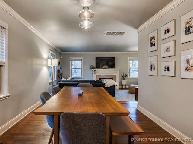 dining area with dark wood-type flooring and crown molding