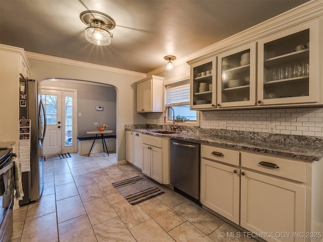 kitchen featuring tasteful backsplash, appliances with stainless steel finishes, sink, and dark stone countertops