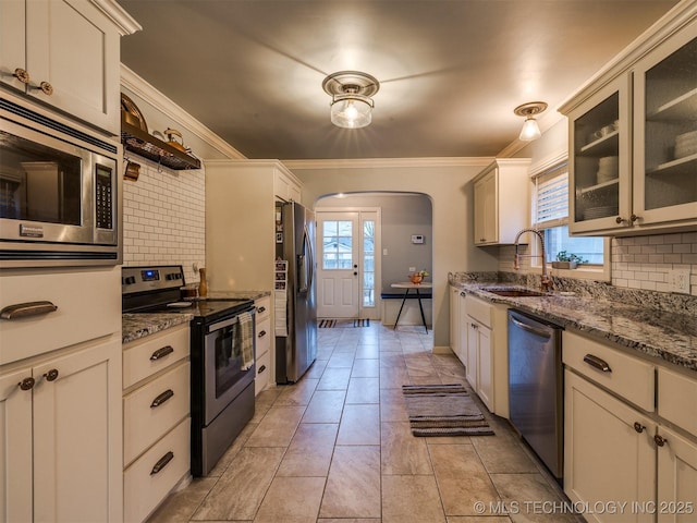 kitchen with tasteful backsplash, sink, crown molding, and appliances with stainless steel finishes