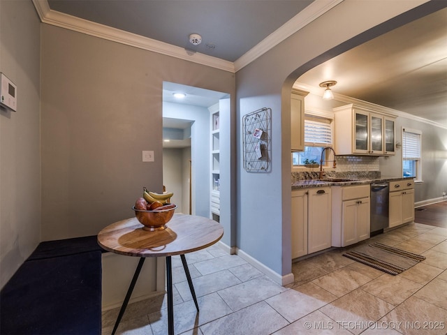 kitchen featuring sink, decorative backsplash, dark stone counters, stainless steel dishwasher, and crown molding