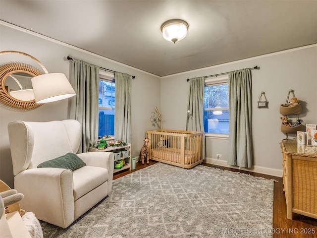 living area featuring wood-type flooring, plenty of natural light, and ornamental molding