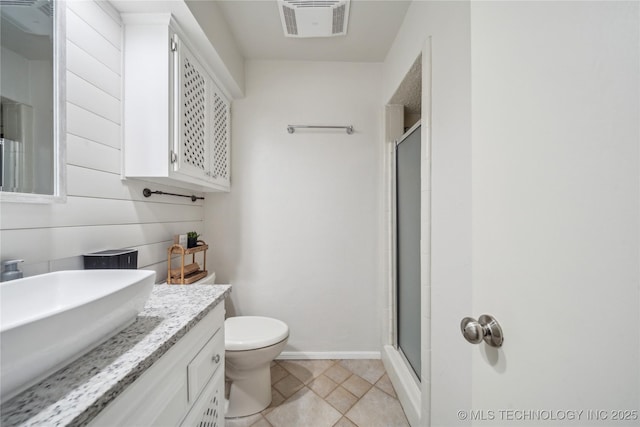 bathroom with tile patterned flooring, toilet, vanity, and walk in shower