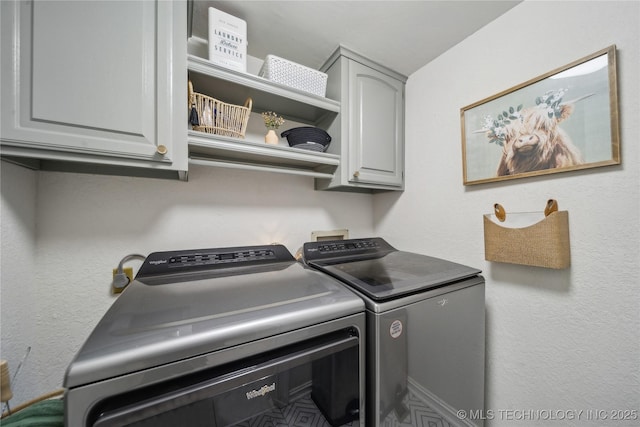 laundry room featuring cabinets and washer and dryer