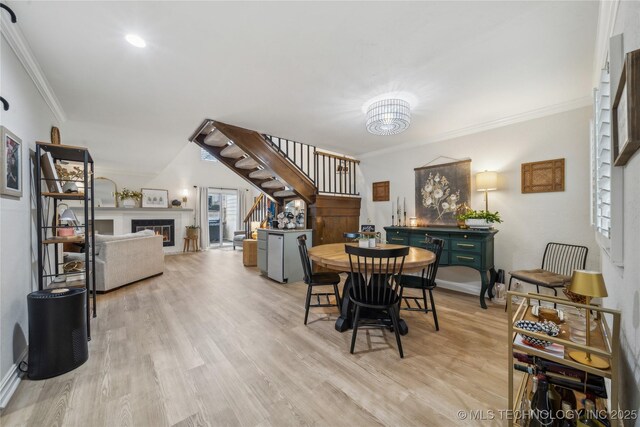 dining space with crown molding and light hardwood / wood-style flooring