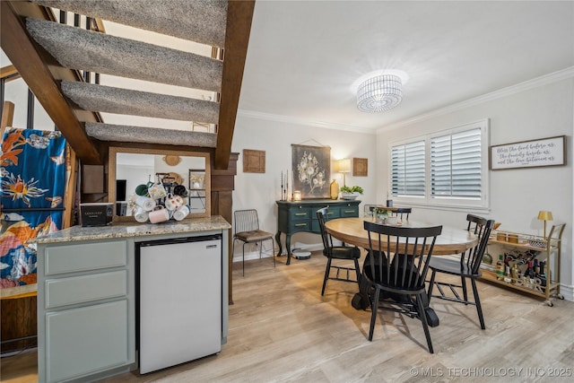 dining area featuring ornamental molding and light wood-type flooring