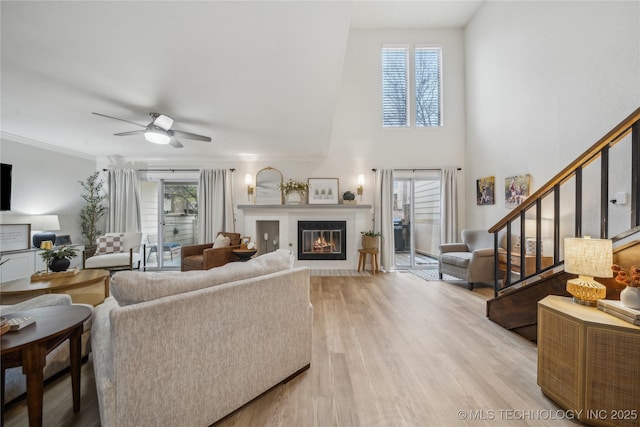 living room featuring ceiling fan, plenty of natural light, light hardwood / wood-style floors, and ornamental molding