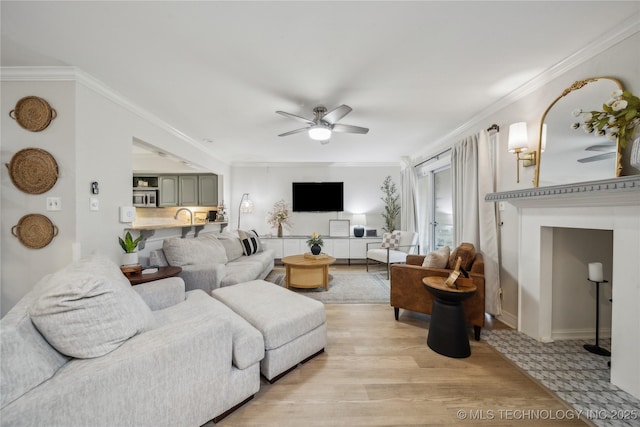 living room with light hardwood / wood-style flooring, ornamental molding, and ceiling fan