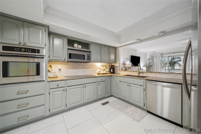 kitchen with stainless steel appliances, crown molding, sink, and light stone counters