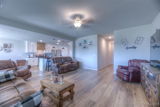 living room featuring ceiling fan and light wood-type flooring