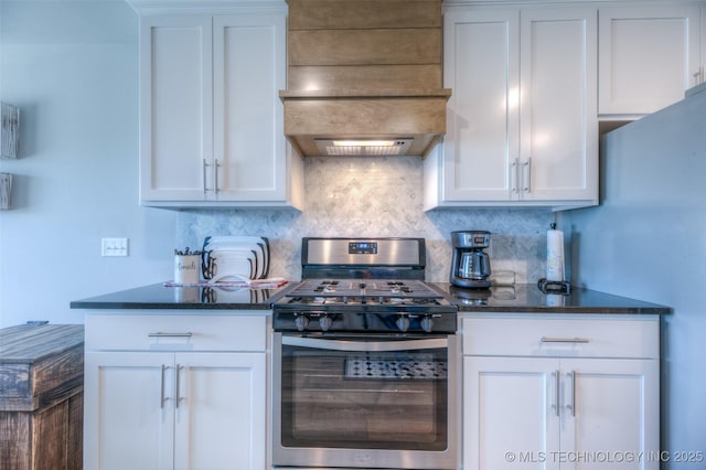 kitchen with backsplash, stainless steel range with gas cooktop, custom range hood, and white cabinets