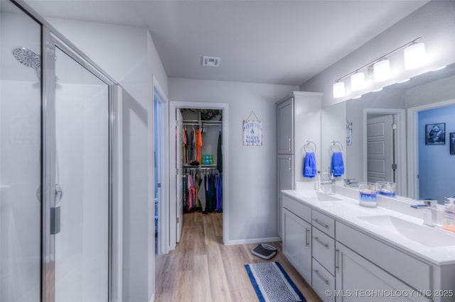 bathroom featuring vanity, hardwood / wood-style flooring, and walk in shower