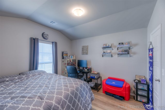 bedroom with vaulted ceiling and wood-type flooring