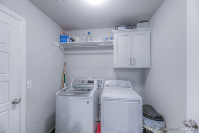 clothes washing area featuring independent washer and dryer and cabinets