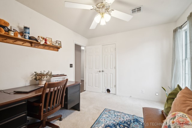 carpeted office space featuring ceiling fan