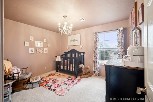 carpeted bedroom with a textured ceiling and a notable chandelier