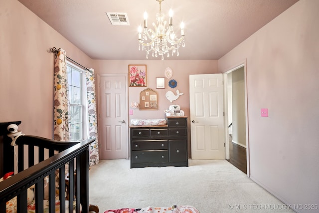 carpeted bedroom featuring an inviting chandelier