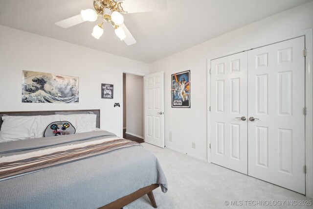 carpeted bedroom with ceiling fan and a closet