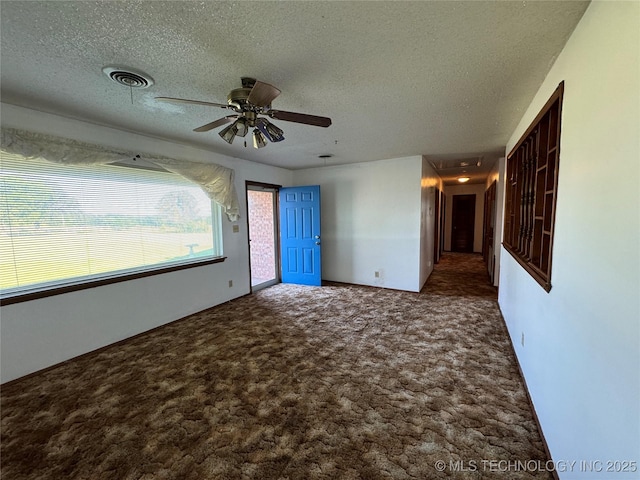 carpeted empty room with ceiling fan and a textured ceiling