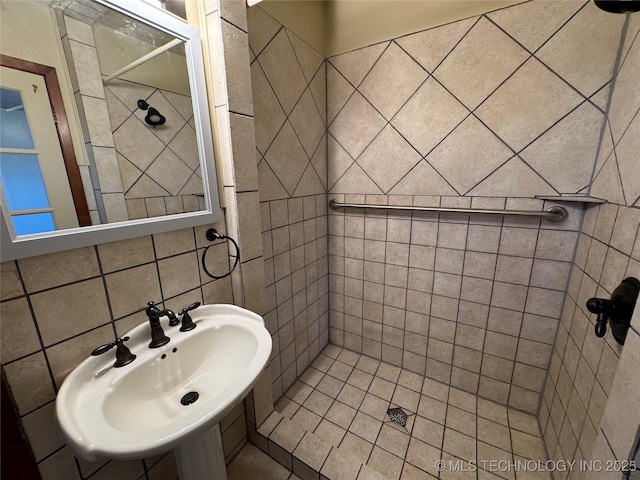 bathroom with a tile shower, sink, and decorative backsplash