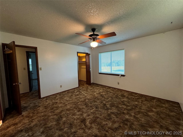 unfurnished bedroom featuring dark colored carpet, ceiling fan, a textured ceiling, and a closet