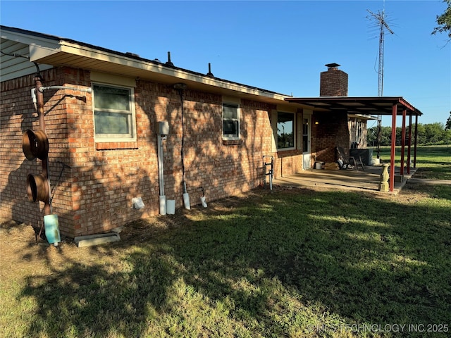 back of house with a lawn and a patio area