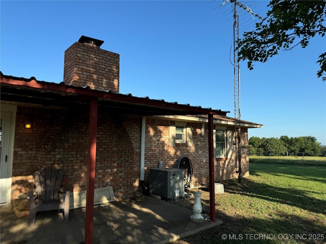 back of house featuring central AC and a yard