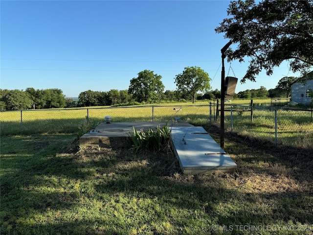 entry to storm shelter with a rural view and a lawn