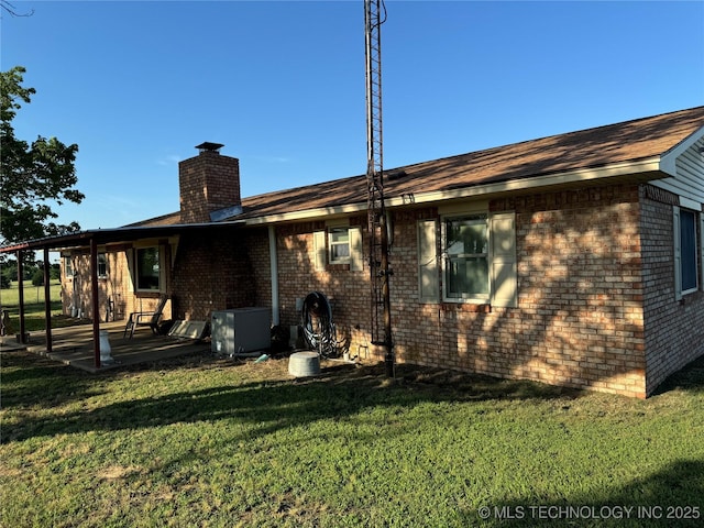 rear view of property with a yard and a patio area