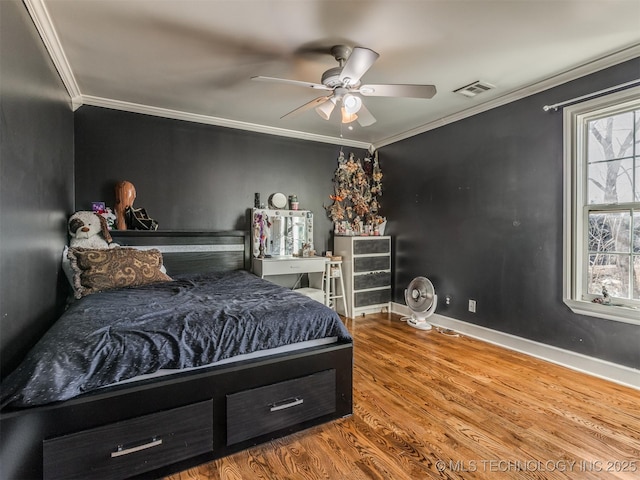 bedroom with hardwood / wood-style floors, ornamental molding, and ceiling fan