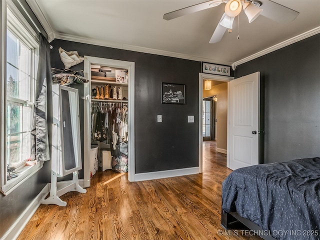 bedroom with multiple windows, ornamental molding, hardwood / wood-style floors, and ceiling fan