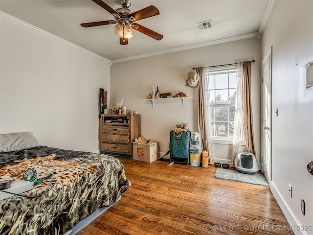 bedroom with wood-type flooring, ornamental molding, and ceiling fan