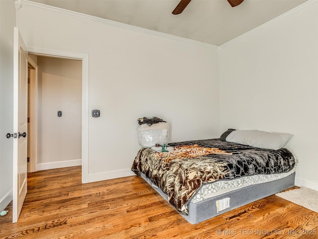 bedroom featuring wood-type flooring, ceiling fan, and crown molding