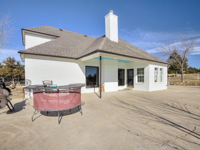 rear view of house with a jacuzzi and a patio area