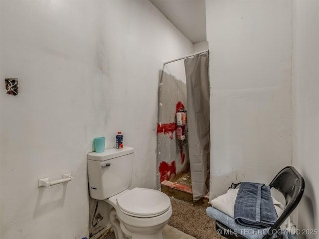 bathroom with a shower with curtain and toilet