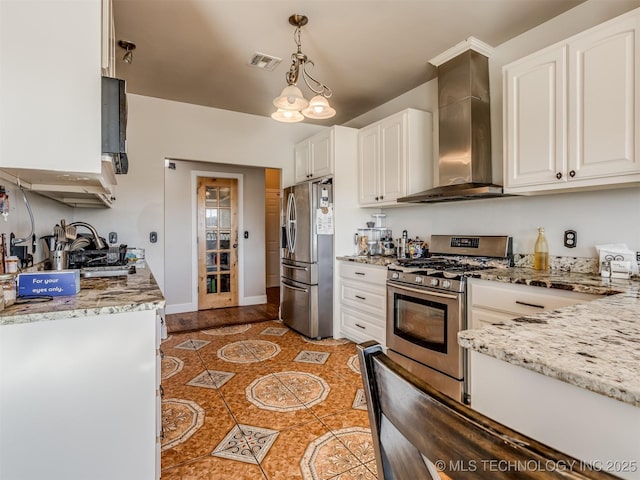 kitchen with decorative light fixtures, white cabinetry, stainless steel appliances, light stone countertops, and wall chimney range hood