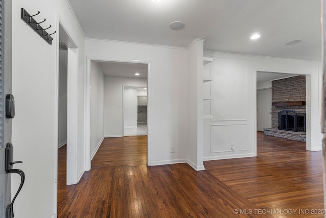 corridor with dark hardwood / wood-style flooring and ornamental molding