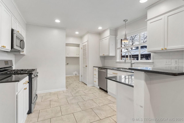 kitchen with appliances with stainless steel finishes, pendant lighting, sink, white cabinets, and ornamental molding